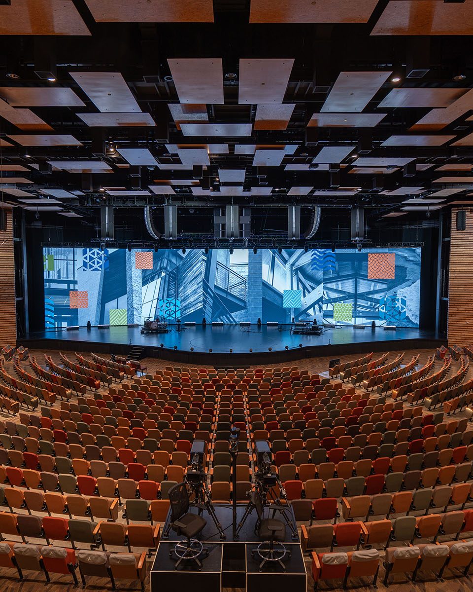 Watermark Church auditorium with a wide LED stage wall lit in blue above curved rows of seating